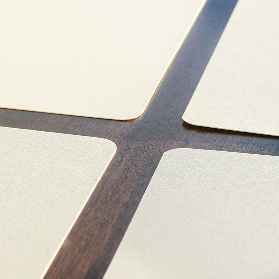 Closeup of four blank white note cards laying on a wooden table top.