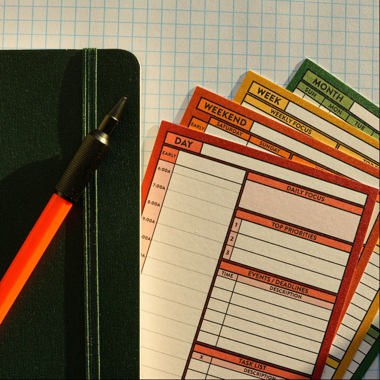 Colorful daily planner cards with a pen on a grid background
