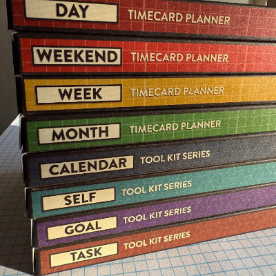 Stacked colorful packaging for Better Made Plans planning cards listing the names of cards in each box and the series.