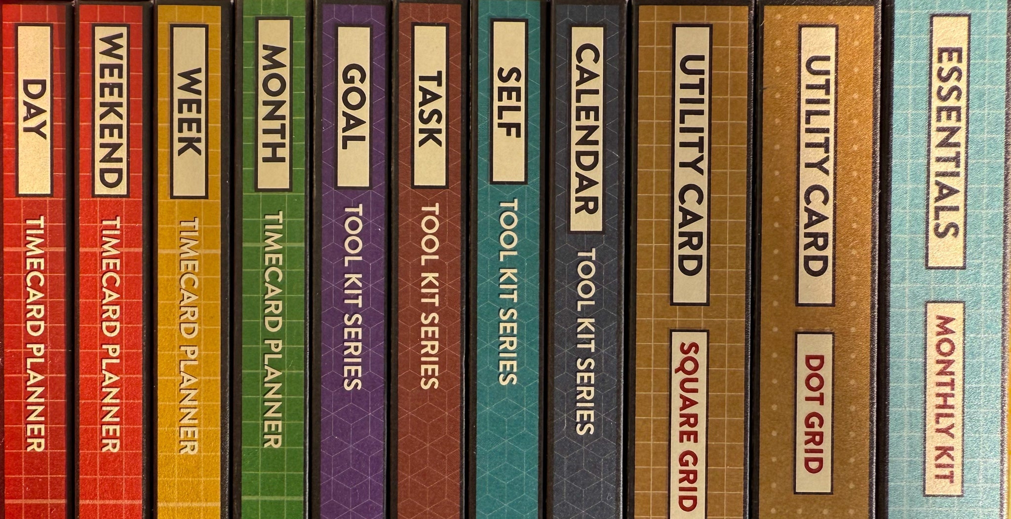 Colorful spines of the packaging for the Better Made Plans planning cards showing the name of each card type and the product series.