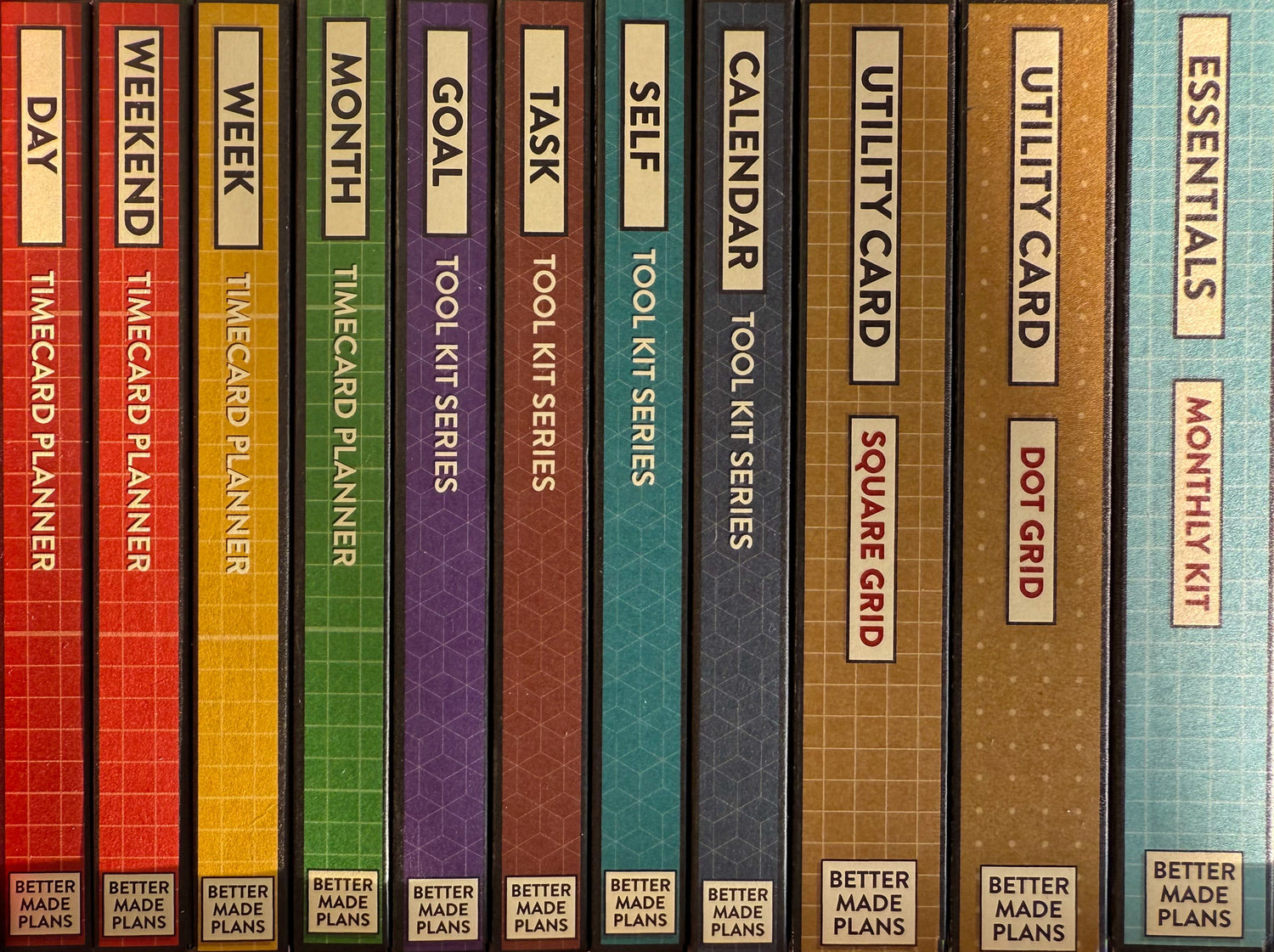 Colorful spines of packaging for Better Made Plans planning cards listing the names of cards in each box and the series.