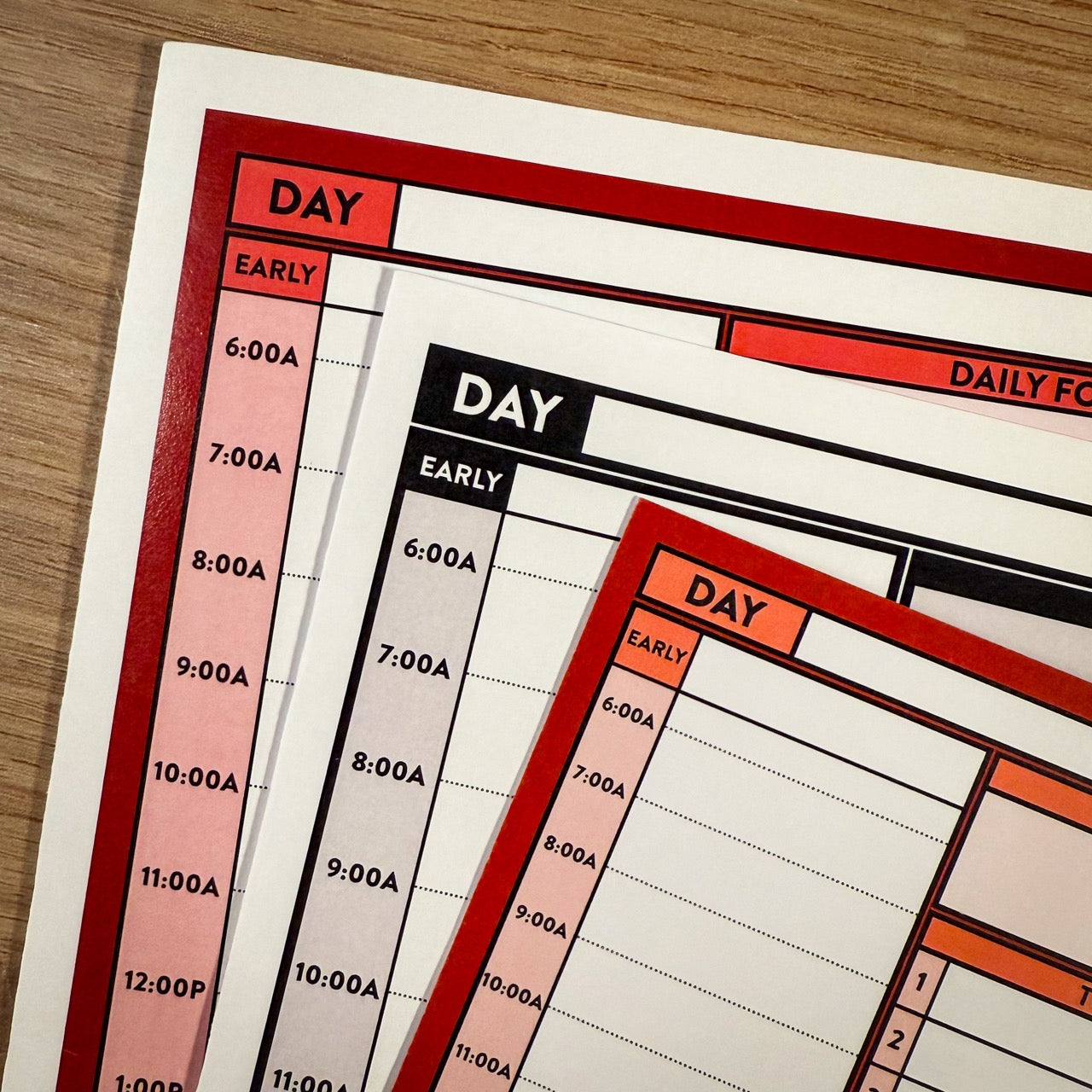 Stack of planners including Better Made Plans color and monochromatic Planning Sheets and Better Made Plans planning card.