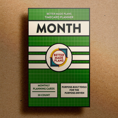 Better Made Plans Timecard Series Month Edition planner packaging on a brown background.