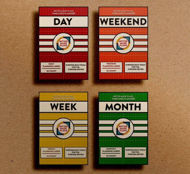 Packaging for the Better Made Plans Timecard Series of Planners including Day, Weekend, Week, and Month editions laying on a brown paper background 