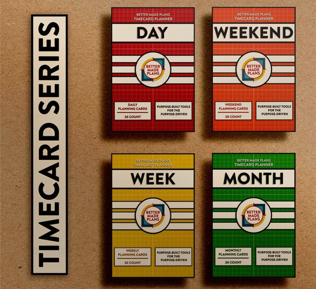 Packaging for the Better Made Plans Timecard Series of Planners including Day, Weekend, Week, and Month editions laying on a brown paper background with a black-and-white label saying "Timecard Series"