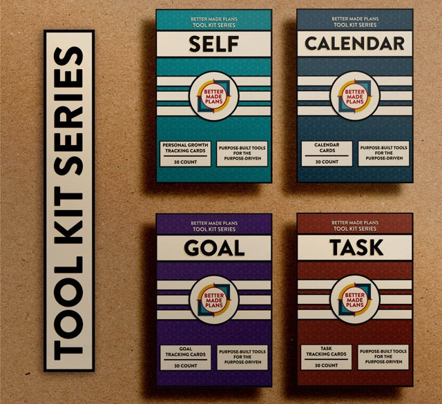 Packaging for the Better Made Plans Tool Kit Series of Planners including Self, Calendar, Goal, and Task editions laying on a brown paper background with a black-and-white label saying "Tool Kit Series"