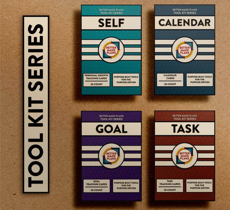 Packaging for the Better Made Plans Tool Kit Series of Planners including Self, Calendar, Goal, and Task editions laying on a brown paper background with a black-and-white label saying "Tool Kit Series"
