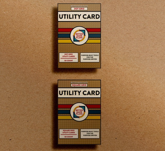 Packaging for Better Made Plans Dot Grid and Square Grid Utility Card Series planners laying on a brown paper background.