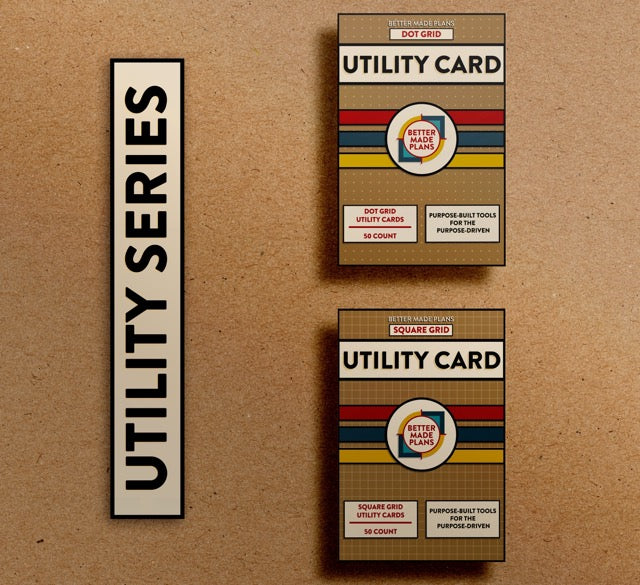 Packaging for Better Made Plans Dot Grid and Square Grid Utility Card Series planners laying on a brown paper background with a black-and-white label saying "Utility Series"
