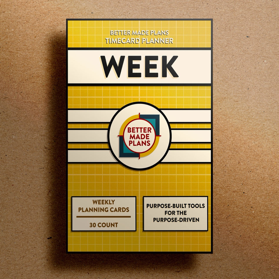 Better Made Plans Timecard Series Week Edition planner packaging on a brown background.